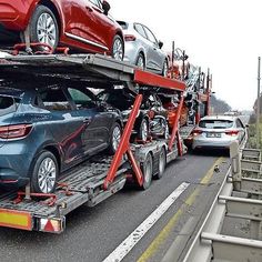 two cars are on the back of a tow truck