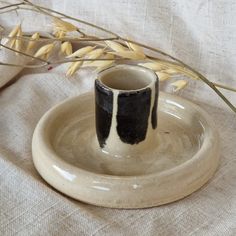 a black and white vase sitting on top of a plate