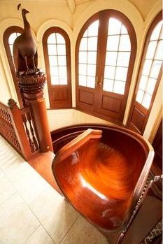 a large wooden bowl in the center of a room with arched windows and an animal statue