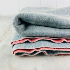 three different colored blankets stacked on top of each other