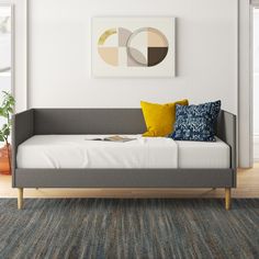 a living room with a gray couch and yellow pillows on it's back end