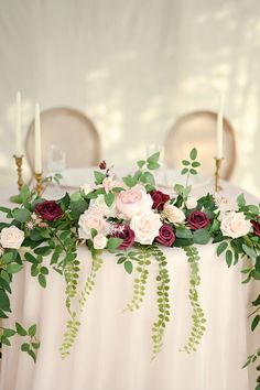 the table is covered with flowers and greenery