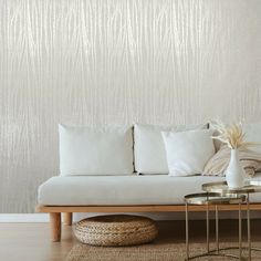 a white couch sitting next to a wooden table on top of a hard wood floor