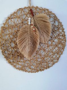 two tassels hanging from a wall on a rope netted doily with white beads