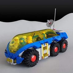 a toy truck with legos in the back and on the front, is shown against a white background