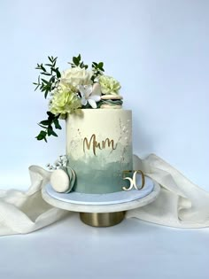 a cake decorated with flowers and the word mum on it is sitting on a plate