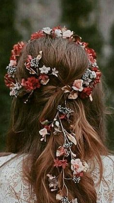 a woman with long hair and flowers in her hair is wearing a flowered headpiece