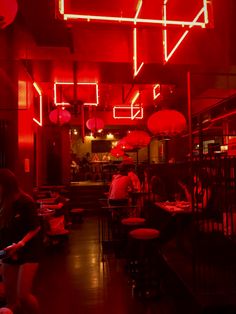 the interior of a restaurant with red lighting