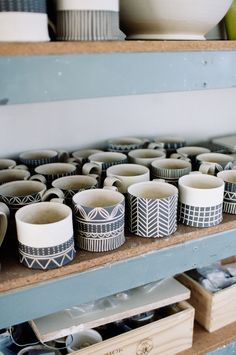 cups and bowls are sitting on the shelves