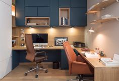 a home office with blue cabinets and brown leather chairs