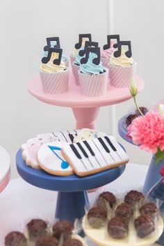 a table topped with cakes and cupcakes covered in frosting next to a cake stand