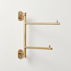 two brass handles on a white wall