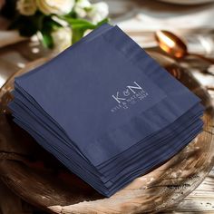 a stack of blue napkins sitting on top of a wooden plate