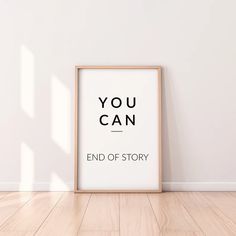 an empty wooden frame on the floor in front of a white wall that says you can end of story