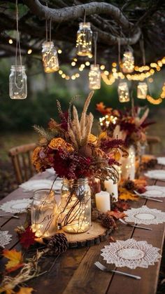 an outdoor table with candles and fall decorations