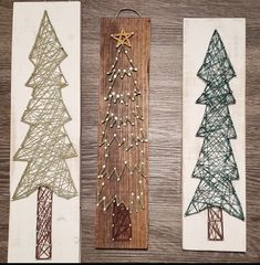 three christmas trees made out of string on wooden boards