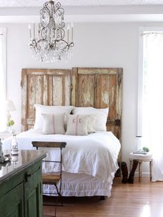 a bedroom with a bed, chandelier and wooden headboard