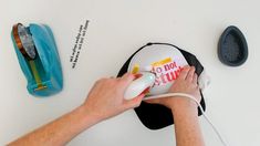 a person using a hair dryer on top of a white table next to other items