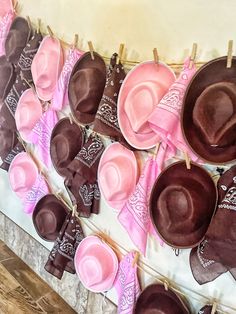 pink and brown hats are hung on clothes pins, with hearts hanging from them to dry