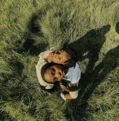 two people standing in the grass looking up