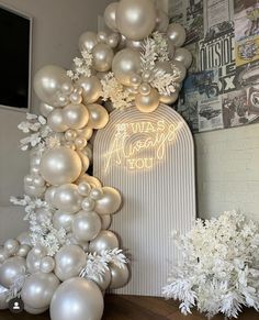 white balloons and snowflakes are on display in front of a sign that says happy new year