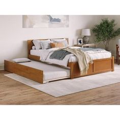 a bed sitting on top of a wooden floor next to a white rug in a bedroom