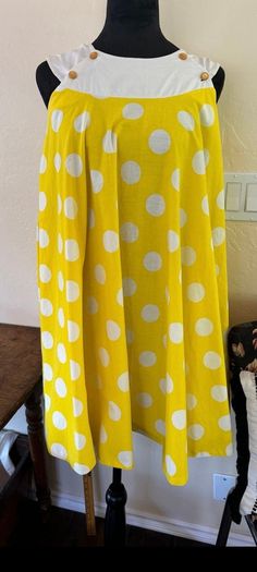 Vintage 1960's trapeze dress is bright lemon yellow with large white polka dots. Sleeveless dress has a white neckline with buttons that open, possibly to be used as a Maternity dress. Dress is a full circle, very full. Made of unlined cotton. Very good condition with a few light stains on front. Please see photos for more details. Measurements- Bust-36" Waist- Free Hips-Free Length from Shoulder-34" Trapeze Dress, Full Circle, Light Stain, Lemon Yellow, Maternity Dress, Vintage 1960s, Large White, Dress Clothes For Women, Maternity Dresses