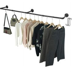 a rack with pants and purses hanging from it