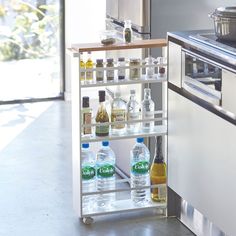 a kitchen with an oven and shelves filled with bottles