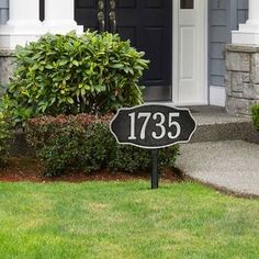 a black and gold address sign in front of a house