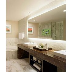 a bathroom with two sinks and a bathtub next to a mirror on the wall