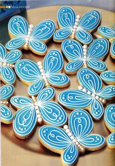 decorated cookies with blue and white butterflies on a wooden platter, ready to be eaten