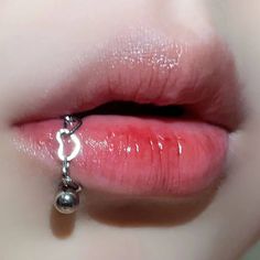 a close up of a person's lips with a chain on the tip of their lip