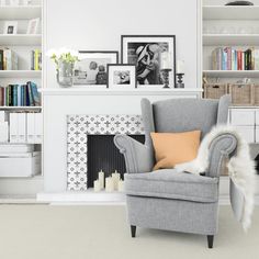 a living room filled with furniture and bookshelves next to a fire place covered in pictures