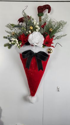 a red and white christmas decoration hanging on the wall next to a door with decorations