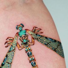 a woman's thigh with tattoos on it and an ornate dragonfly tattoo design