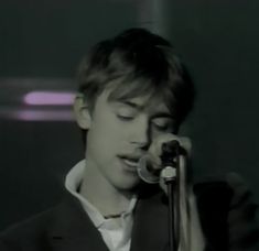 a young man holding a microphone up to his face