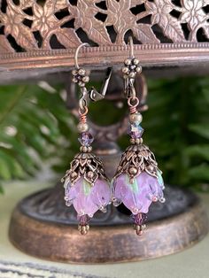 a pair of earrings with pink and green beads hanging from it's earwires