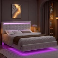 a large bed with purple lights on the headboard and foot board in a bedroom