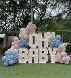 a large sign that says oh baby surrounded by balloons and lights in the shape of letters