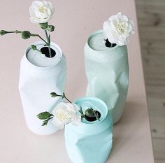 two vases with flowers in them sitting on a table