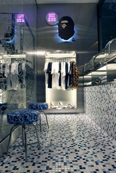 the inside of a clothing store with blue and white tiles