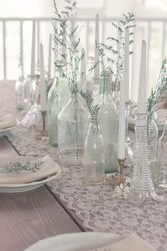 a table with vases and candles on it