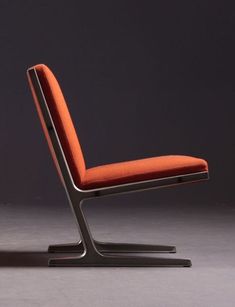 an orange chair sitting on top of a gray floor