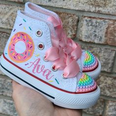 How adorable!  Rows of pastel pearls on the toes and donuts on the sides along with your little one's name in pink glitter script writing.  Please choose your child's size during check out. Feel free to contact me with any questions regarding sizing or anything else prior to your purchase.  I answer very quickly! Pink Round Toe Sneakers For Birthday, Casual Pink Sneakers For Birthday, Cute High-top Sneakers For Birthday, Donut Shoes, Personalized Converse, Shoes Sneakers High Tops, Bedazzled Shoes, Minnie Mouse Shoes, Painted Shoes Diy