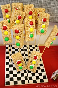 rice krispy treats are arranged on top of a checkered tablecloth with candy