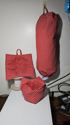 two red and white bags sitting on top of a table next to an electric device