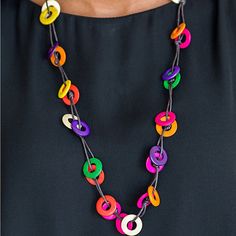 a woman wearing a multicolored necklace and black dress with colorful beads on it