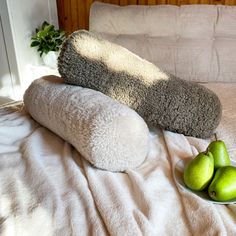 two towels and some pears on a bed