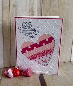 a valentine's day card with two hearts and chocolates on the table next to it